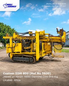 Yellow diamond-core drilling rig on a dirt lot under a blue sky; white text overlay shows 'Custom EDM 800 (Ref No 5830) Diamond Core Drill Rig Located: Africa'